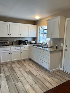 Kitchen with microwave, toaster oven, hot skillet, French press, and utensils