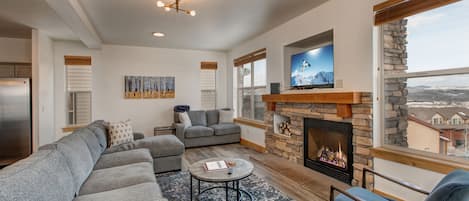 Main Level Living room with ample seating throughout the large sectional sofa, plush loveseat and two contemporary chairs. A gas fireplace, 50" Samsung smart tv, and private deck access make this the perfect room to gather and spend a night in