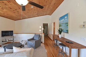 The living room has two seating areas and flatscreen TV with treetop views from anywhere in the room.