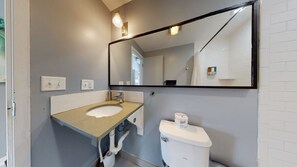 A private bathroom with a beautiful white tile enclosed shower.