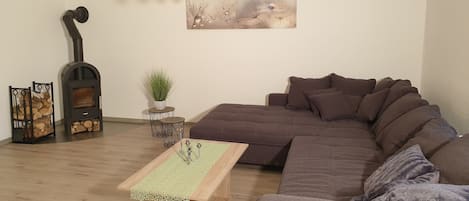 Wohnzimmer mit Couch, TV und Kamin