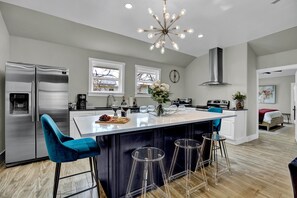 The center kitchen island, complete with seating, offers a perfect hub for gathering, cooking, and enjoying meals in one inviting space.