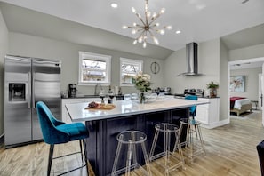 The center kitchen island, complete with seating, offers a perfect hub for gathering, cooking, and enjoying meals in one inviting space.