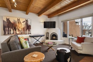 Living area with kiva fireplace, piano, smart TV and a sleeper sofa