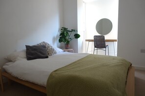 A comfy double bed, with a dressing table and mirror.
