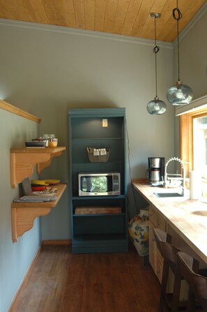 From entry door, view into kitchenette and seating area overlooking vineyard.