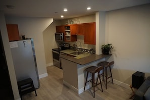 Full kitchen with bar-top, doubles as compact work space. Modern appliances. 
