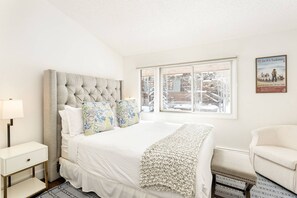 The comfortable queen bedroom looks out at Aspen Mountain and has warm and inviting color palette.