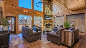 View into the 2 story living room with a river rock fireplace.