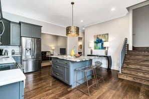 The lower level features a second full living space, complete with kitchen, two king bedrooms, one queen bedroom, two three-quarter baths, one half bath, plus access to the hot tub, backyard, and garage/game-room!
