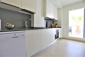 New and modern kitchen is fully equipped and has extra laundry room and balcony access