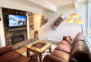 Living area with two comfy couches, gas fireplace and smart tv