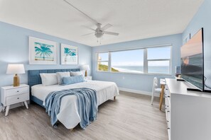 Serene bedroom with soft hues and breathtaking water views.