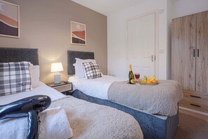 The master bedroom has a private en-suite shower, a Smart TV with Netflix subscription included, and a comfortable zip-link bed which is configured as two single beds by default or can be zipped together to form a king-size bed upon request.