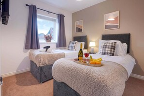 The master bedroom has a private en-suite shower, a Smart TV with Netflix subscription included, and a comfortable zip-link bed which is configured as two single beds by default or can be zipped together to form a king-size bed upon request.