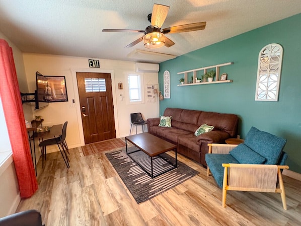 Living room with YouTube TV provided (cable) and plenty of seating with a large window for natural light.