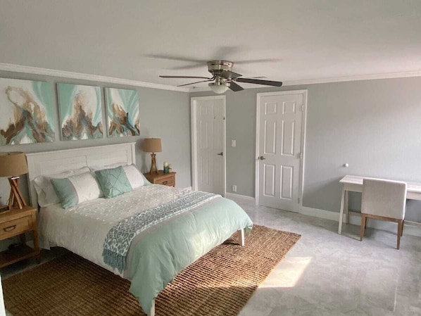 Bedroom with queen size bed and TV.