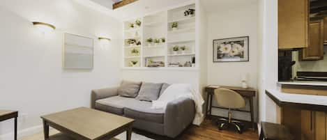 Living room features a sofa, desk, smart TV, and skylight.