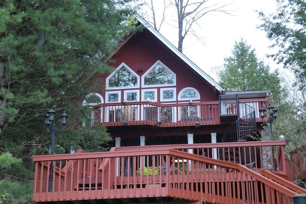 Lakefront chalet with multiple levels of decks leading to the water.