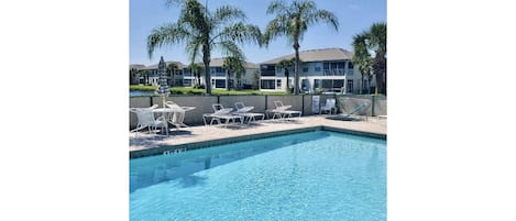 Beautiful pool setting among the palm trees and fountain in adjacent pond.