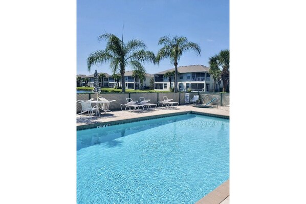 Beautiful pool setting among the palm trees and fountain in adjacent pond.