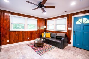 Natural light fills the living room and the door opens to the screened-in porch.