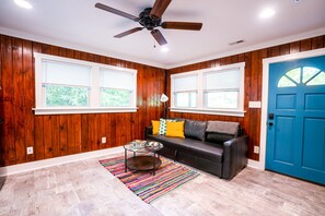 Natural light fills the living room and the door opens to the screened-in porch.