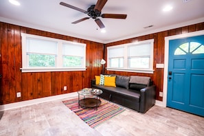 Natural light fills the living room and the door opens to the screened-in porch.