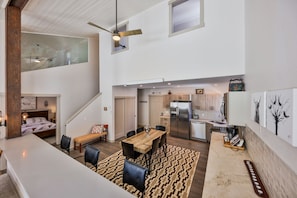 Full and fully stocked kitchen with dining area, bar, table, and chairs.