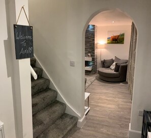 Entrance hall with a welcome sign, shoe rack, and coat hooks.