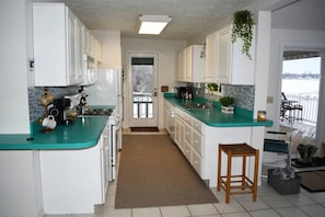 Kitchen with dishes, pots, pans, silverware, coffee pot with K-cup brewer, tea kettle, toaster, crock pot