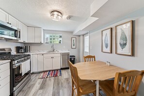 Downstairs kitchen offers 3 regular chairs and two folding chairs tucked by the fridge.