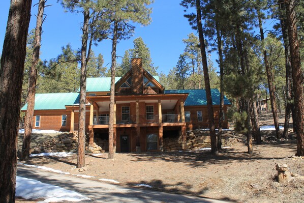 Front view of the house with lower patio and front deck. 