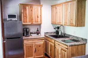 Kitchen with coffee maker, toaster oven, microwave, refrigerator