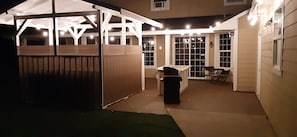 Outdoor hot tub area and outdoor kitchen at night