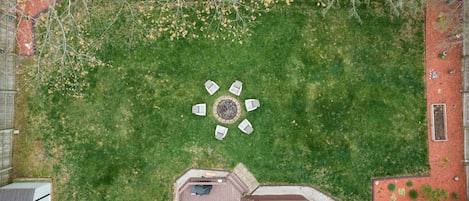 Large fenced backyard with a firepit in the center