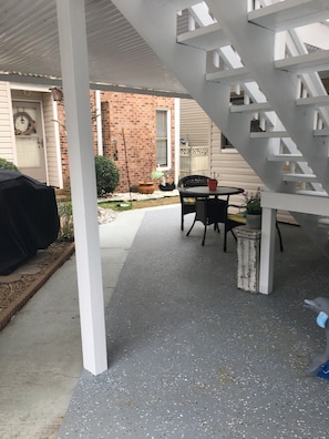 Underneath deck with gas grill and table