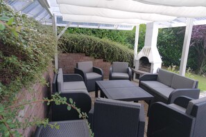 Die Terrasse mit den Lounge-Möbeln und Kamin, der auch als Grill genutzt werden kann.