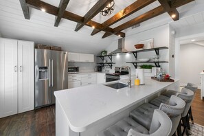 Kitchen fully stocked and stackable washer and dryer to the left of fridge