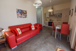 Living room with kitchen, dining table and seating area 