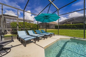 Beautiful  turquoise lounge  chairs and umbrella overlooking screened in porch