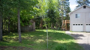View of parking area, side yard and stair to balcony. 