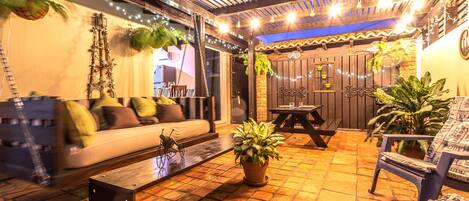 Pleasant outdoor seating area of the Apartment in Noord Aruba - Well-chosen lighting fixtures adding both functionality and charm - Cozy seating area conducive to relaxation and socializing