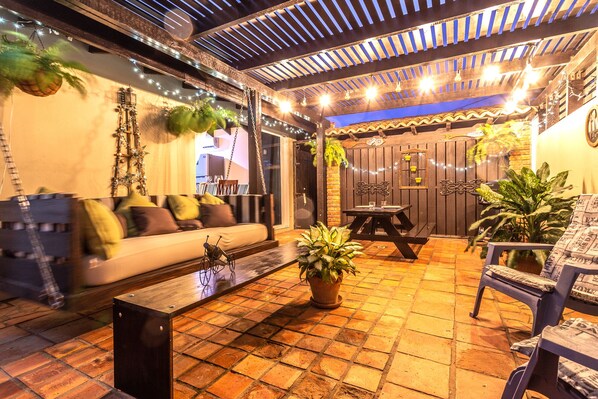 Pleasant outdoor seating area of the Apartment in Noord Aruba - Well-chosen lighting fixtures adding both functionality and charm - Cozy seating area conducive to relaxation and socializing