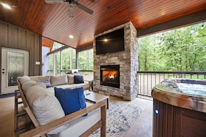 Outdoor living area with fireplace, grill, and 60" TV