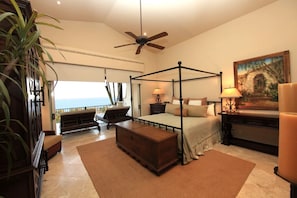 Master bedroom with king size bed, beautiful armoire and side chair.