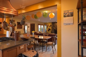 looking from kitchen across breakfast bar through dining do living and fireplace