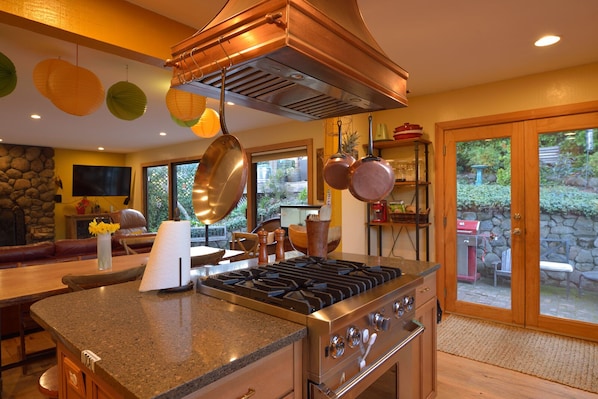 custom copper range hood and stone counters, looking to back patio