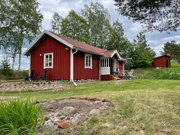 Stugan sedd från dammen i juni