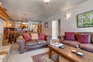 Living Room with plush leather sofas, gas fireplace, 55" LG smart tv, and private hot tub patio access